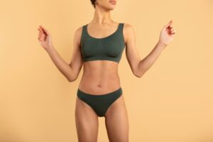 Woman with toned abs and very little fat posing to show the results of her combined tummy tuck and liposuction.