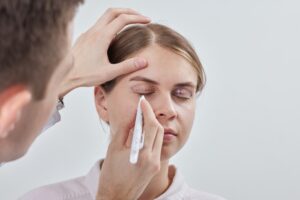 Woman having her eyes drawn on during a consultation for her coming eyelid surgery.